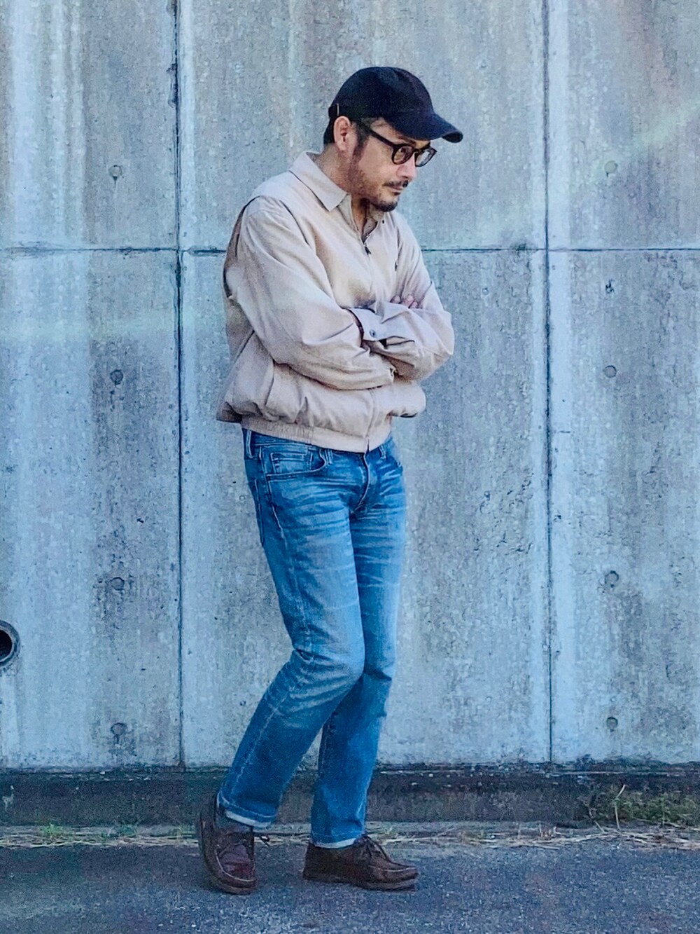 ベージュ系のブルゾン、ブルー系のデニムパンツ、ブラウン系のモカシン/デッキシューズを着用したメンズの秋コーディネートの4枚目の写真