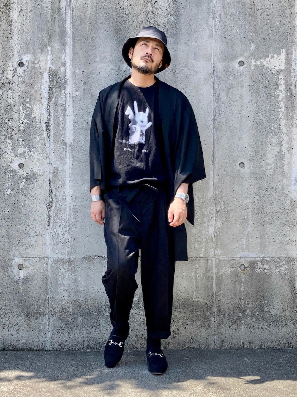 ブラック系のTシャツ/カットソー、ブラック系のスラックス、ブラック系のローファーを着用したメンズの秋コーディネートの2枚目の写真