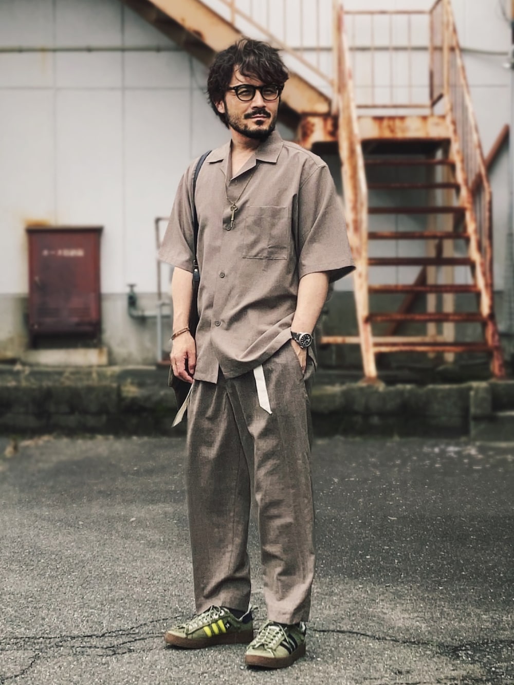 ブラウン系のシャツ/ブラウス、ブラウン系のスラックス、グリーン系のスニーカーを着用したメンズの夏コーディネートの2枚目の写真