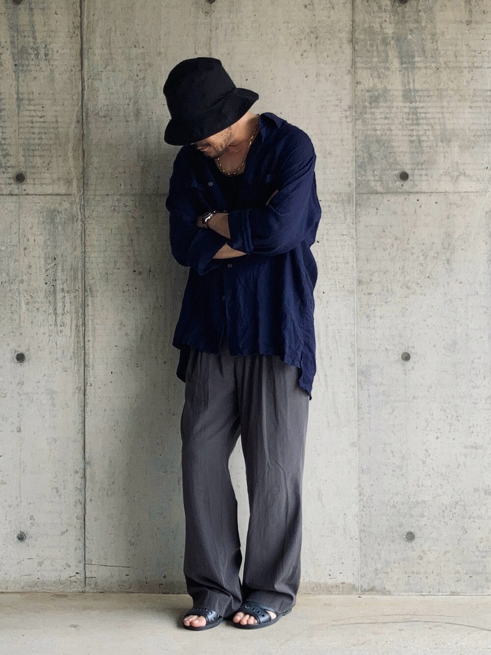 グレー系のスラックス、ブラック系のタンクトップ、ブルー系のシャツ/ブラウスを着用したメンズの春コーディネートの3枚目の写真