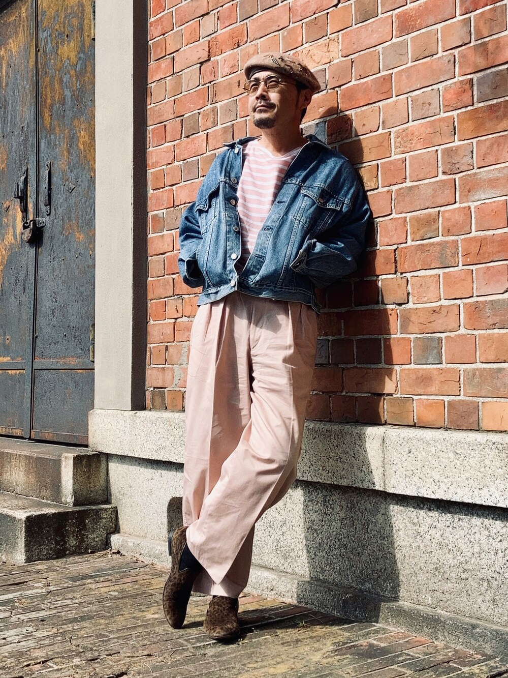 ピンク系のTシャツ/カットソー、ブルー系のデニムジャケット、ピンク系のスラックスを着用したメンズの秋コーディネートの3枚目の写真