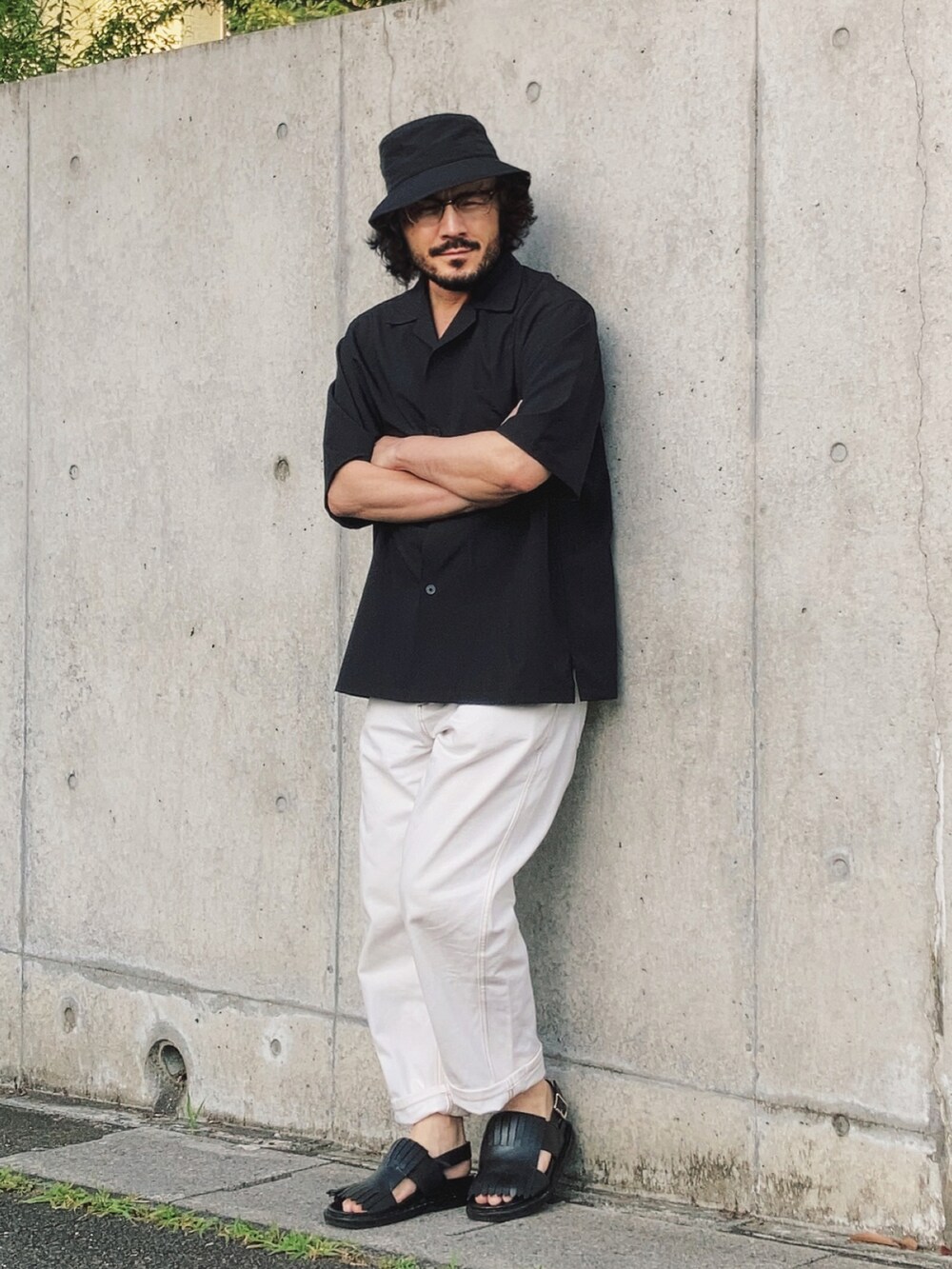 ブラック系のサンダル、ブラック系のシャツ/ブラウス、ホワイト系のデニムパンツを着用したメンズの夏コーディネートの2枚目の写真