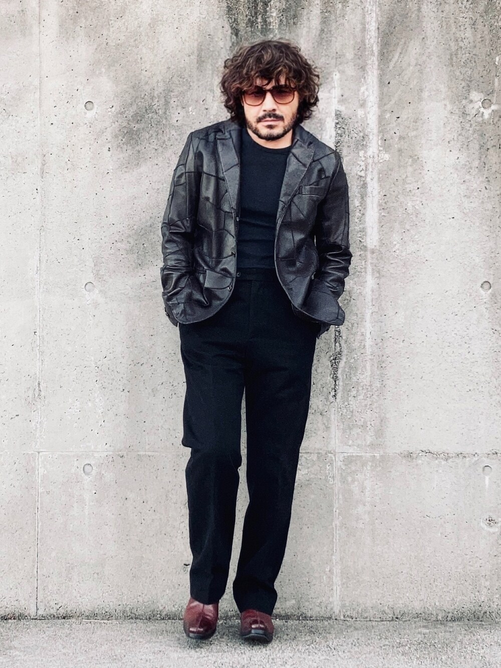 ブラウン系のテーラードジャケット、ブラック系のスラックス、レッド系のブーツを着用したメンズの秋コーディネートの3枚目の写真