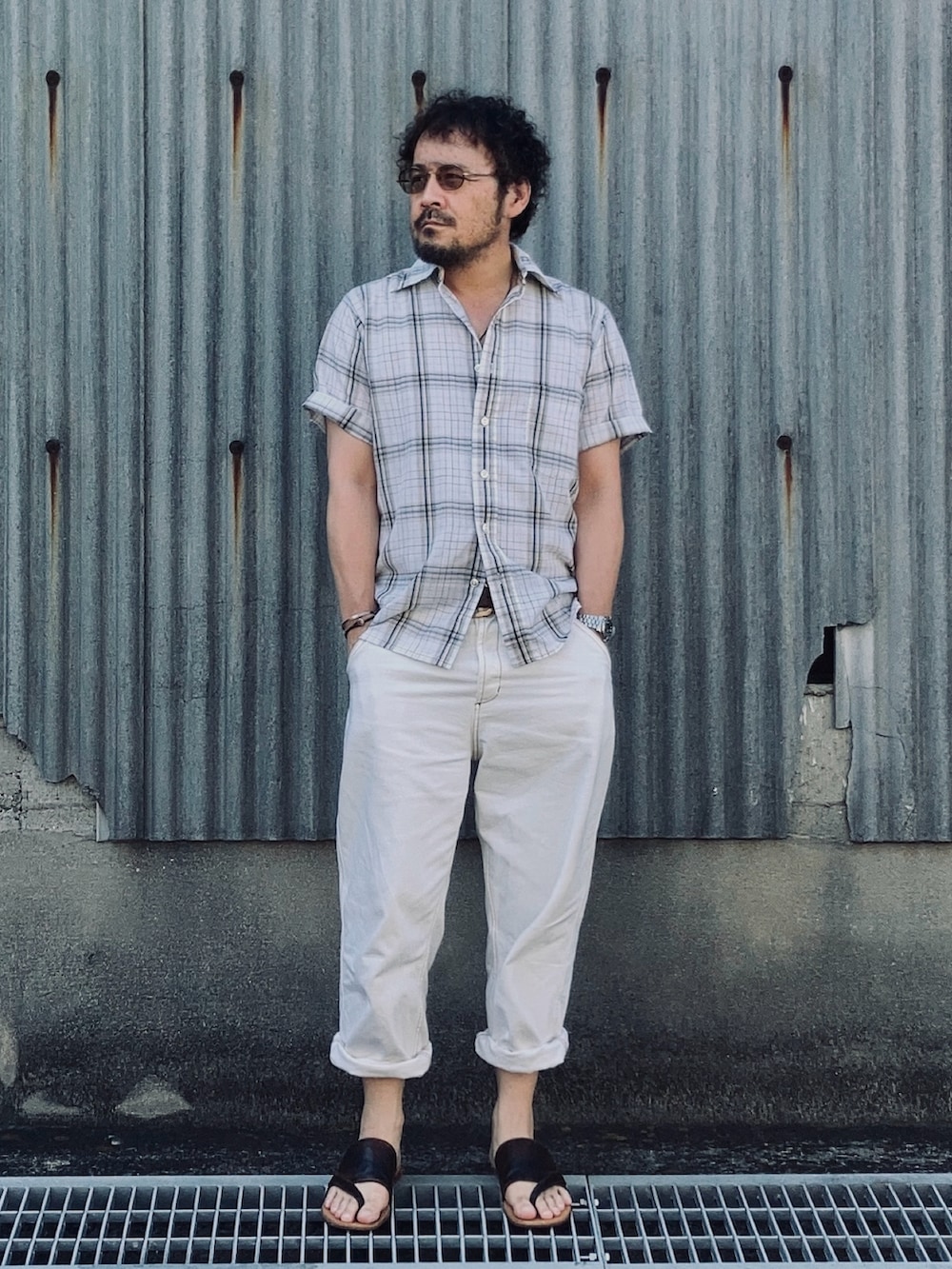 ホワイト系のデニムパンツ、グリーン系のシャツ/ブラウス、ブラウン系のサンダルを着用したメンズの夏コーディネートの2枚目の写真