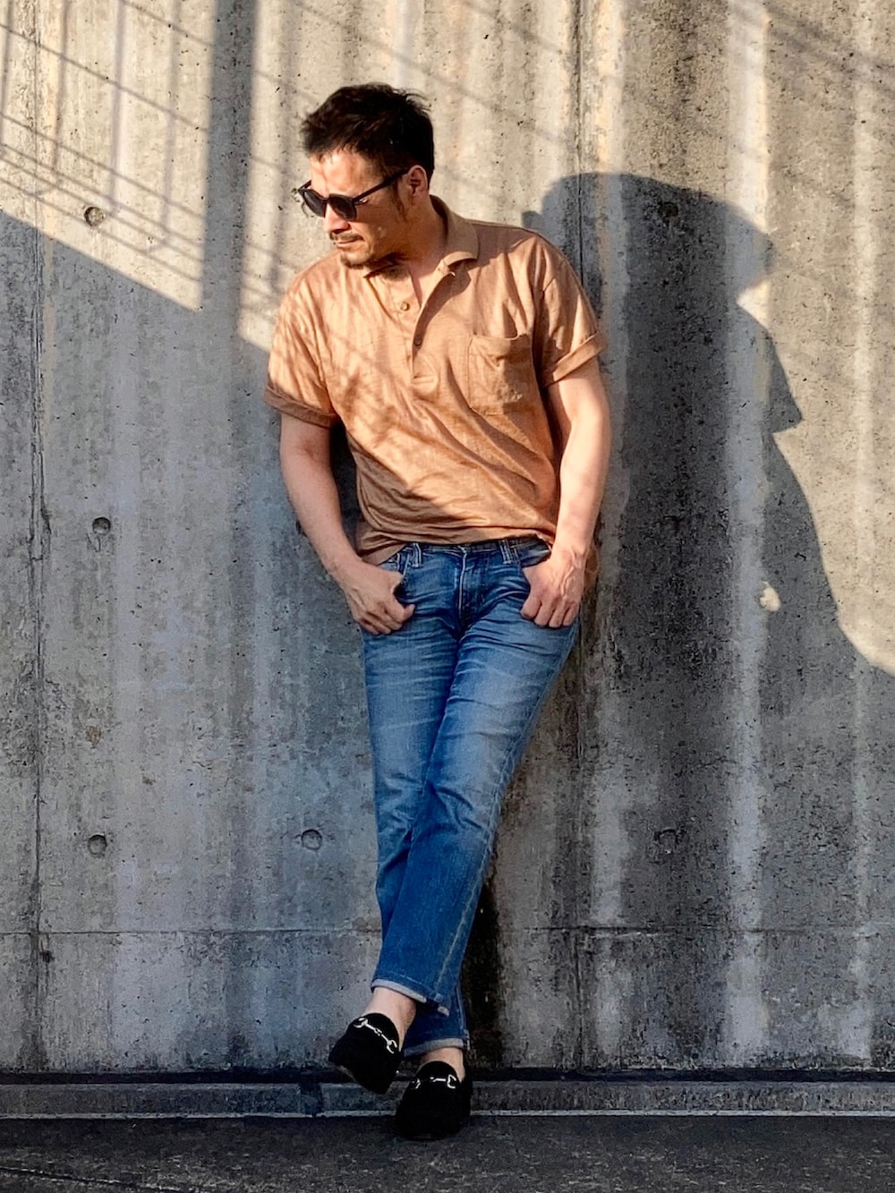 ブラウン系のポロシャツ、ブルー系のデニムパンツ、ブラック系のローファーを着用したメンズの春コーディネートの3枚目の写真