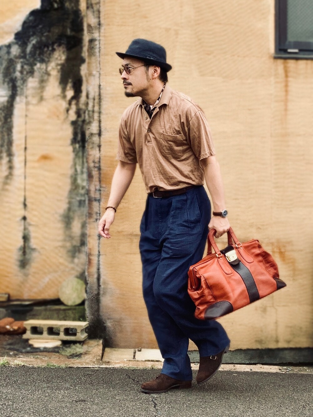 ブラウン系のポロシャツ、ブラウン系のドレスシューズ、ブラウン系のボストンバッグを着用したメンズの夏コーディネートの2枚目の写真