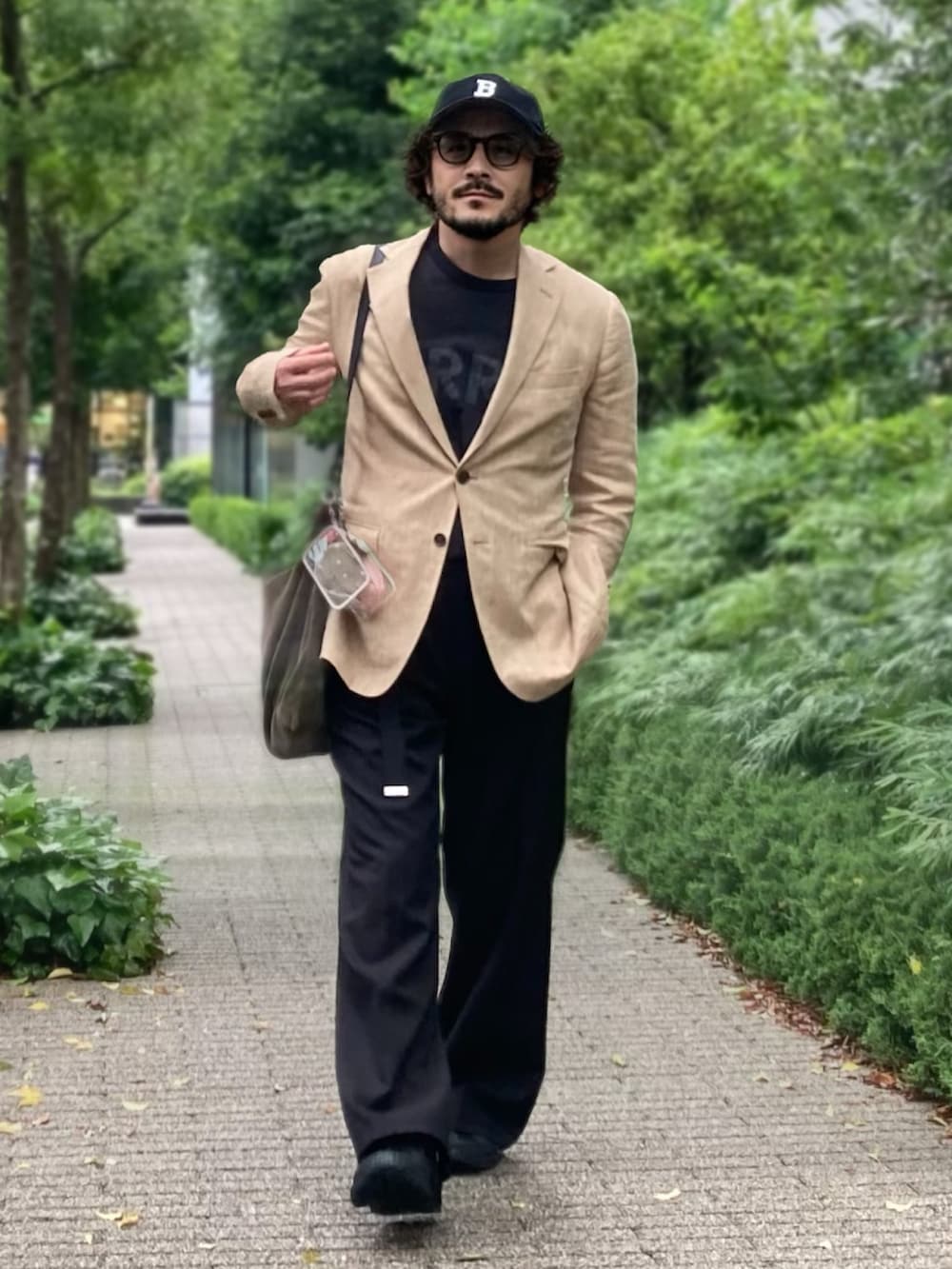 ベージュ系のテーラードジャケット、ブラック系のTシャツ/カットソー、ブラック系のスラックスを着用したメンズの夏コーディネートの2枚目の写真