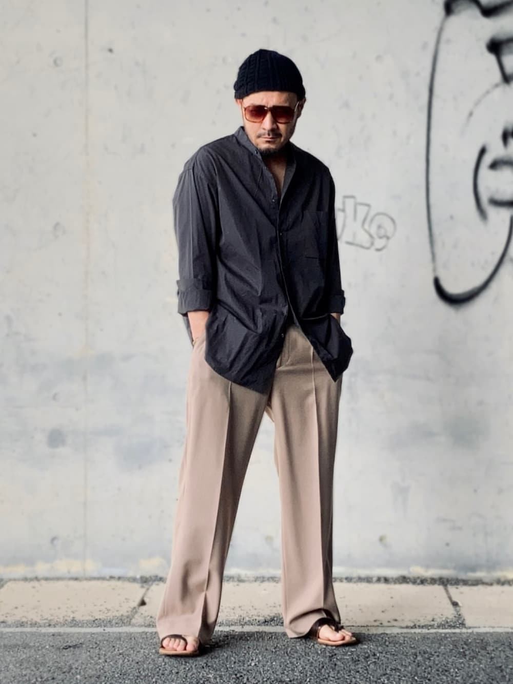 グレー系のシャツ/ブラウス、ベージュ系のスラックス、ブラウン系のサンダルを着用したメンズの夏コーディネートの3枚目の写真