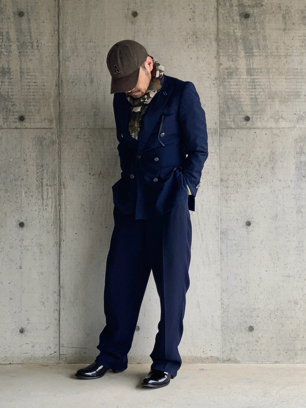 ブルー系のテーラードジャケット、ブルー系のスラックス、グリーン系のポロシャツを着用したメンズの冬コーディネートの2枚目の写真