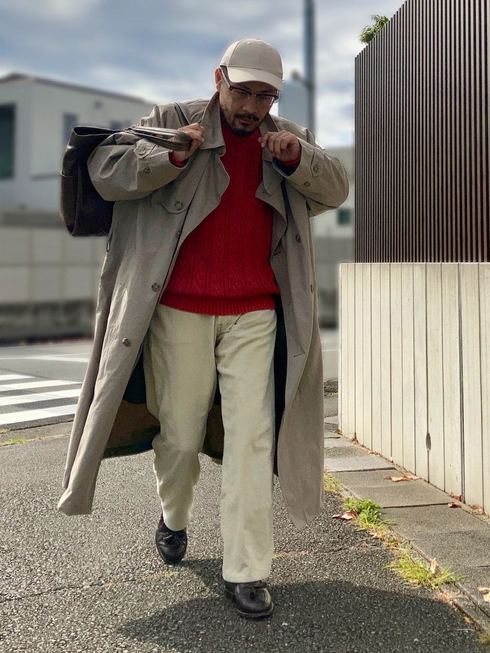 ベージュ系のパンツ、ベージュ系のトレンチコート、レッド系のニット/セーターを着用したメンズの秋コーディネートの2枚目の写真