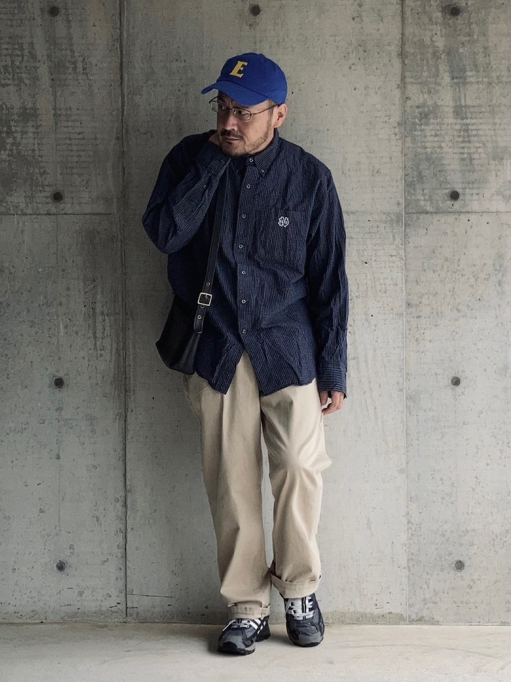 ブルー系のシャツ/ブラウス、ベージュ系のチノパンツ、ブラック系のスニーカーを着用したメンズの秋コーディネートの2枚目の写真