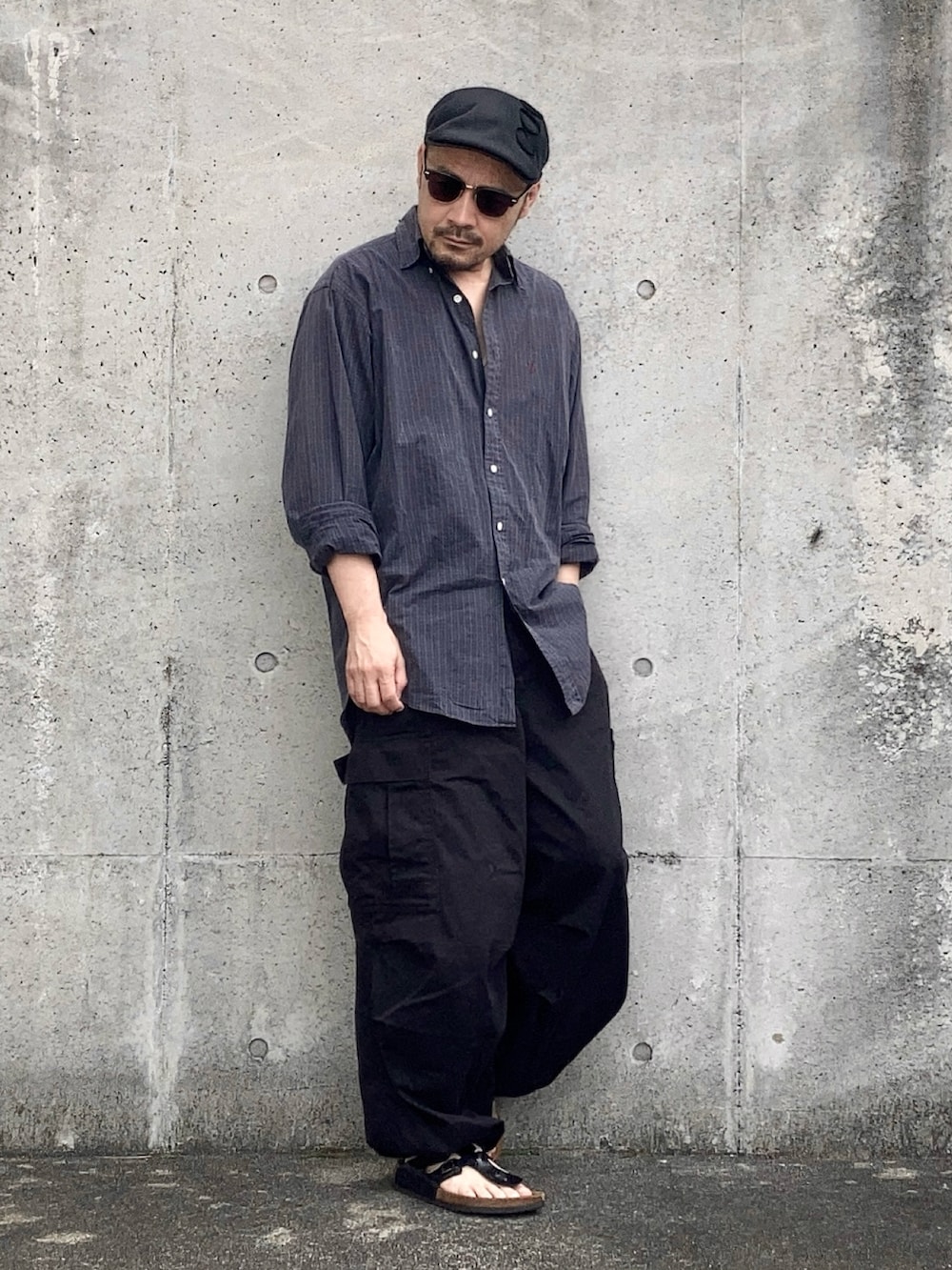 グリーン系のシャツ/ブラウス、ブラック系のカーゴパンツ、ブラック系のサンダルを着用したメンズの夏コーディネートの2枚目の写真