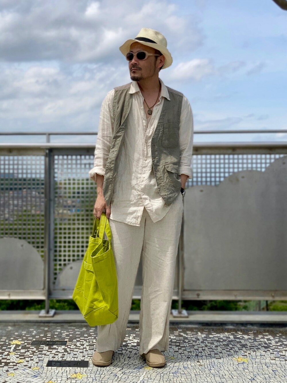 ベージュ系のシャツ/ブラウス、グリーン系のベスト、ベージュ系のパンツを着用したメンズの春コーディネートの2枚目の写真