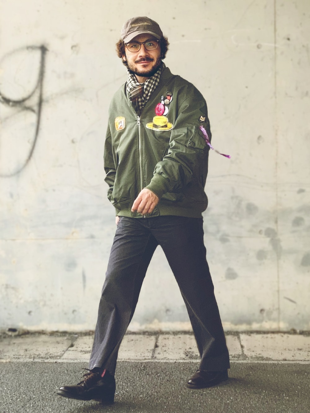 グリーン系のMA-1、ホワイト系のTシャツ/カットソー、グレー系のスラックスを着用したメンズの冬コーディネートの2枚目の写真