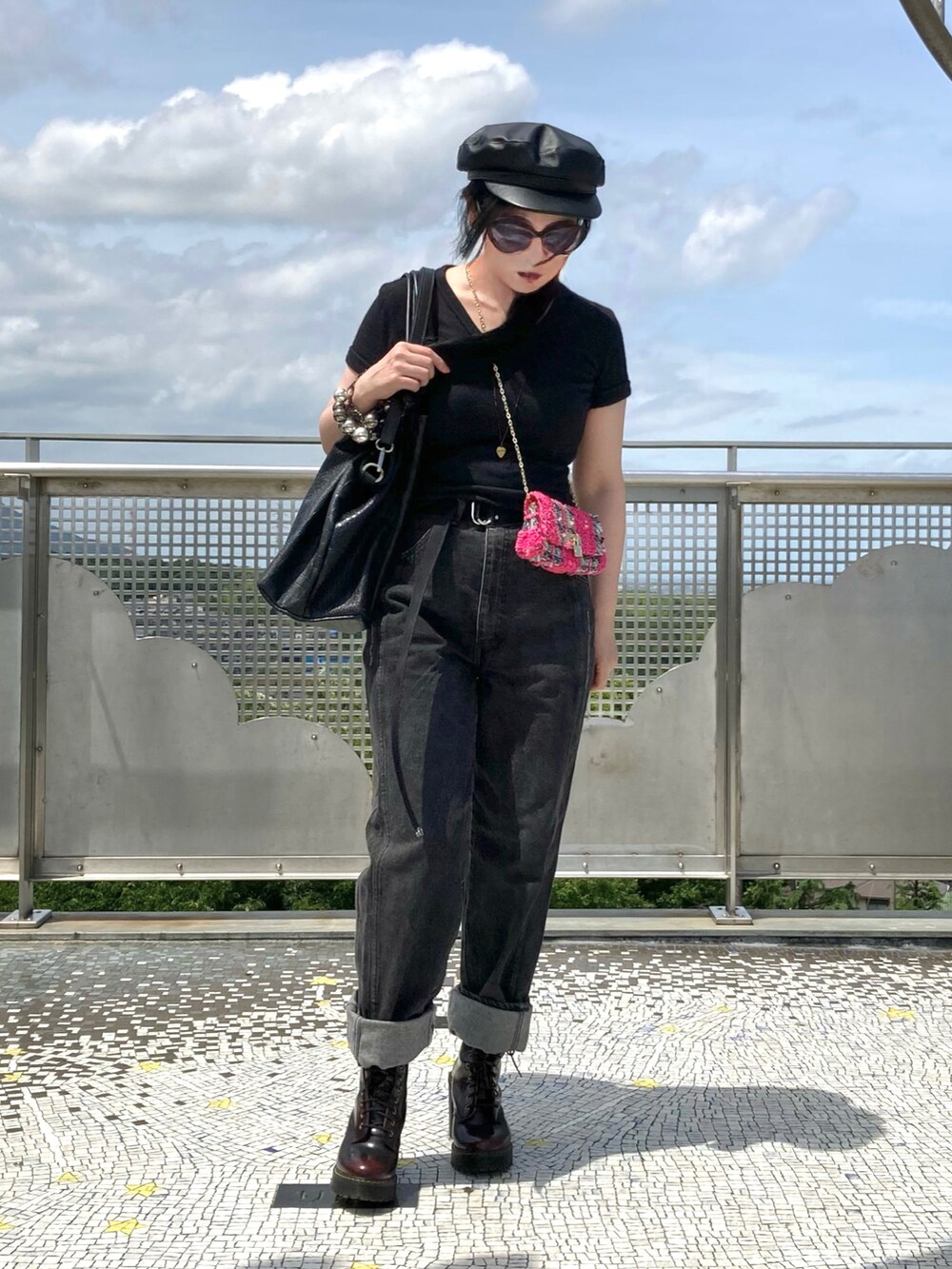 ブラック系のデニムパンツ、ブラウン系のブーツを着用したレディースの春コーディネートの2枚目の写真