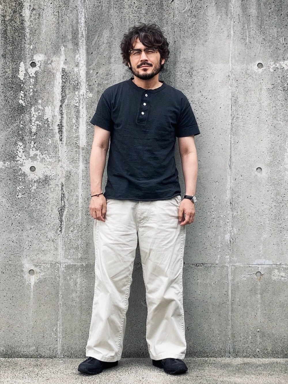 ブラック系のTシャツ/カットソー、ホワイト系のデニムパンツ、ブラック系のスニーカーを着用したメンズの春コーディネートの3枚目の写真