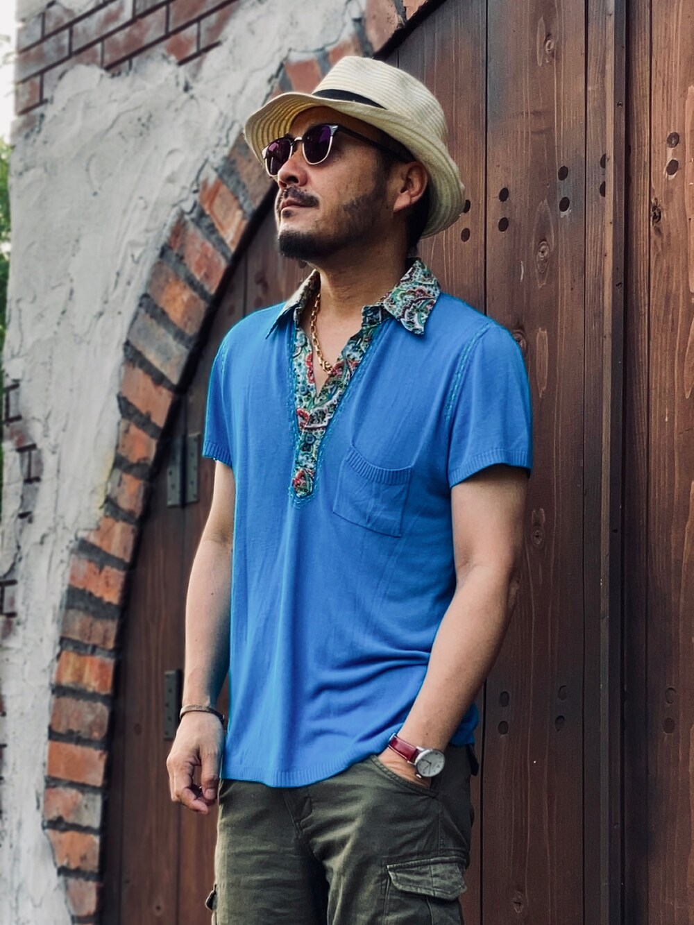 グリーン系のパンツ、ホワイト系のスリッポン、ブルー系のポロシャツを着用したメンズの夏コーディネートの4枚目の写真