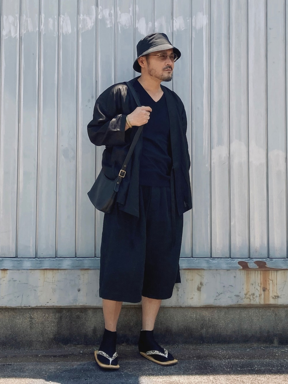 ブラック系のTシャツ/カットソー、ブラック系のその他パンツ、ベージュ系のサンダルを着用したメンズの夏コーディネートの2枚目の写真