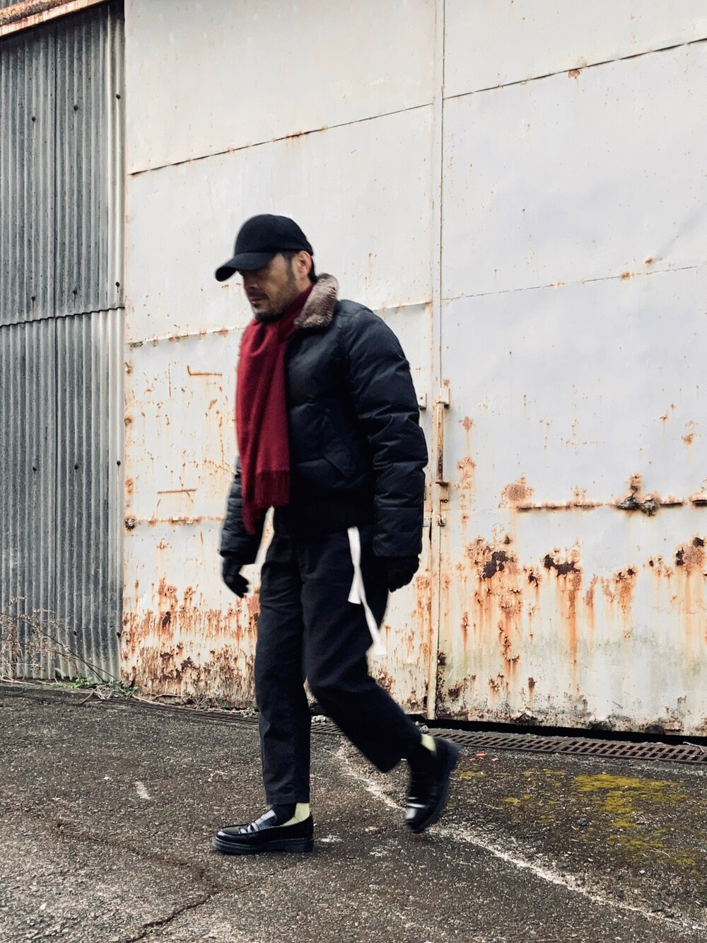 ブラック系のダウンジャケット/コート、ブラック系のその他パンツ、ブラック系のローファーを着用したメンズの冬コーディネートの3枚目の写真