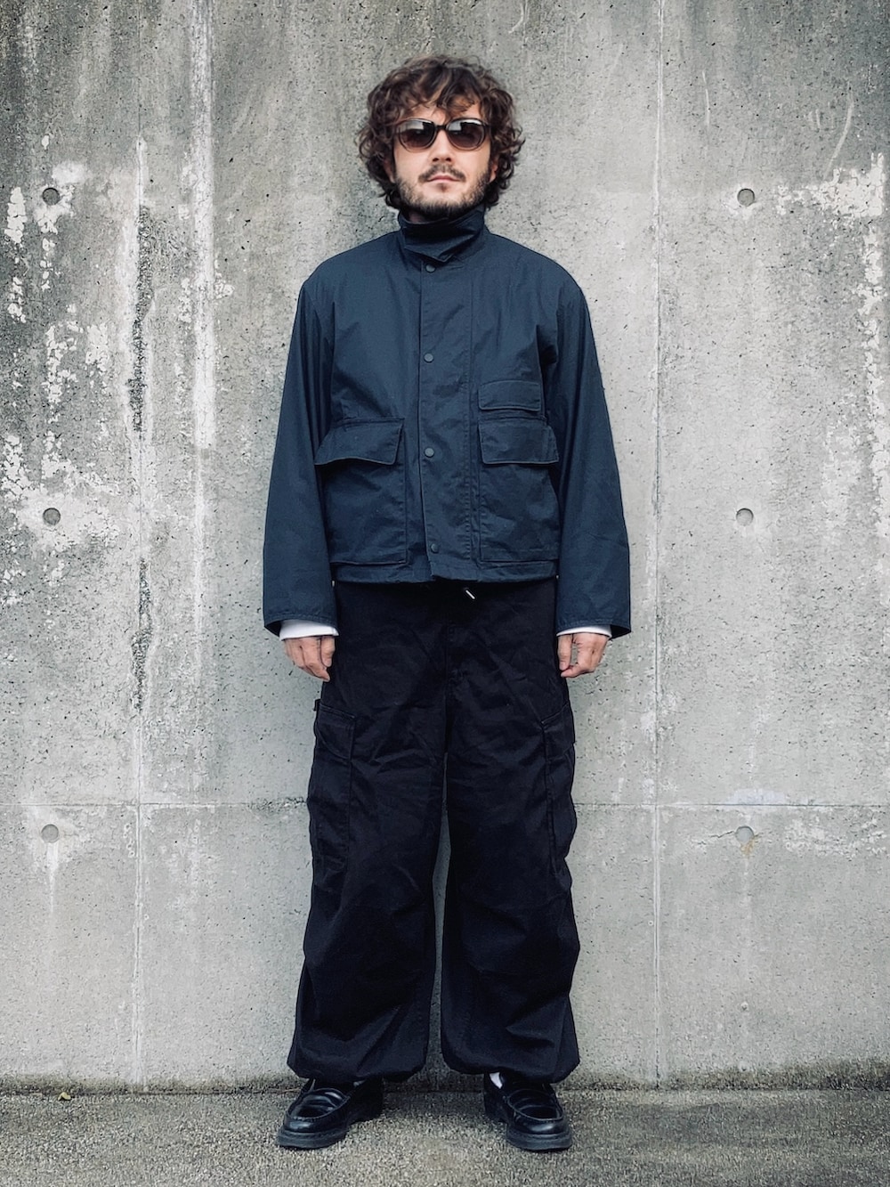 ブルー系のマウンテンパーカー、ホワイト系のTシャツ/カットソー、ブラック系のカーゴパンツを着用したメンズの冬コーディネートの3枚目の写真