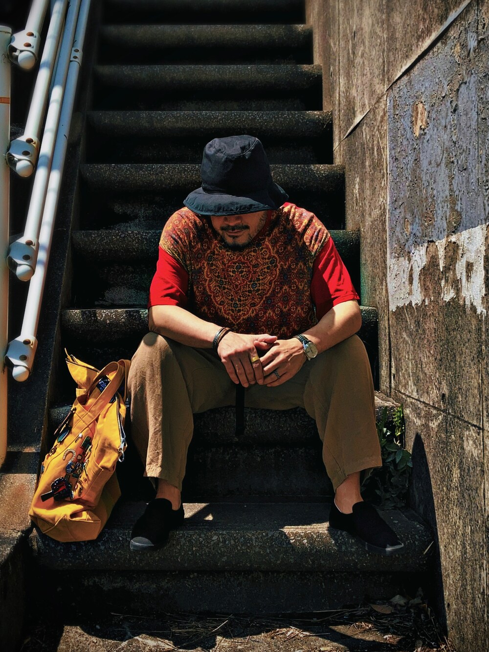 レッド系のTシャツ/カットソー、ベージュ系のその他パンツ、ブラック系のスリッポンを着用したメンズの春コーディネートの3枚目の写真