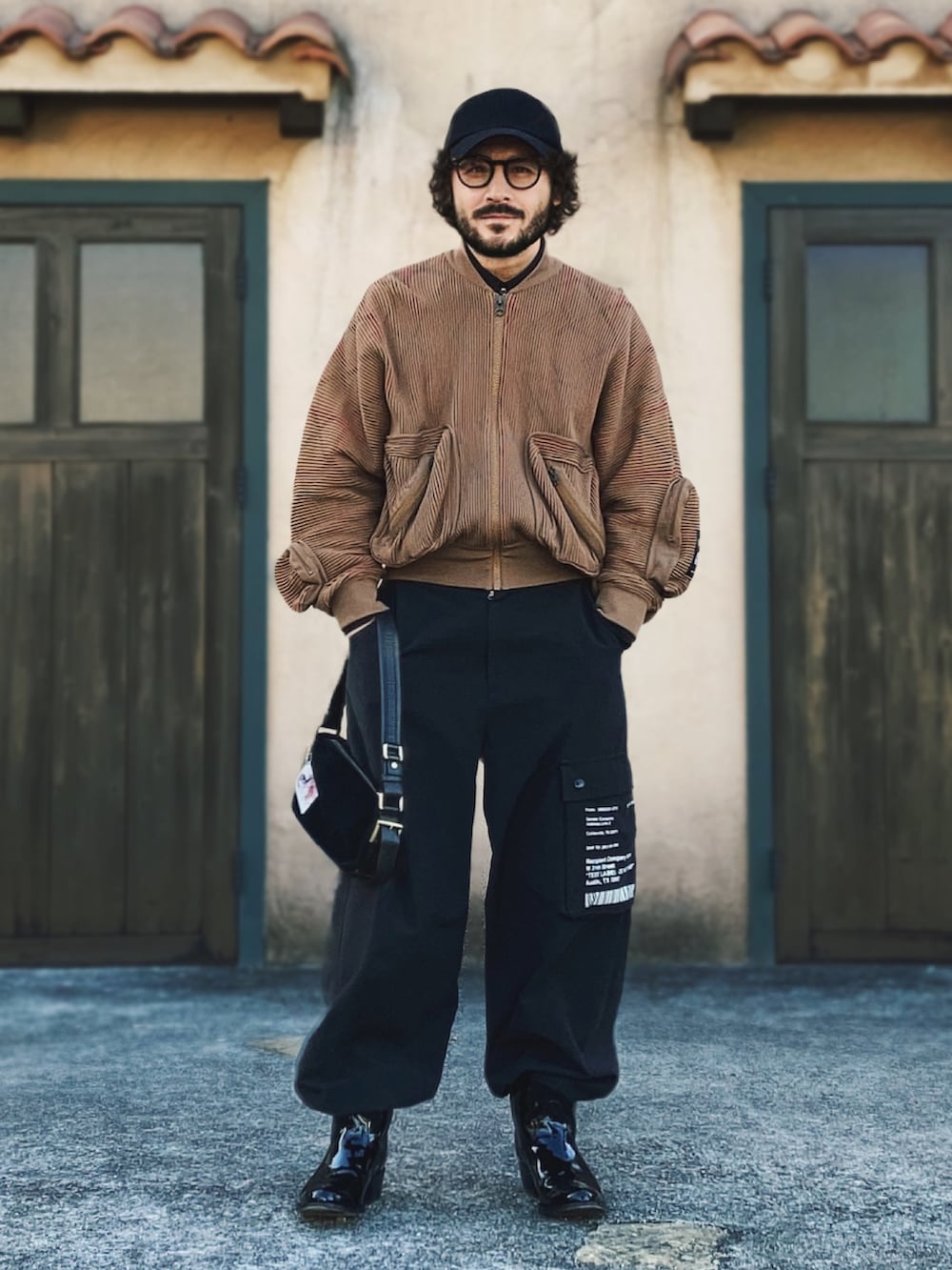 ブラウン系のMA-1、ブラック系のパンツ、ブラック系のブーツを着用したメンズの秋コーディネートの2枚目の写真