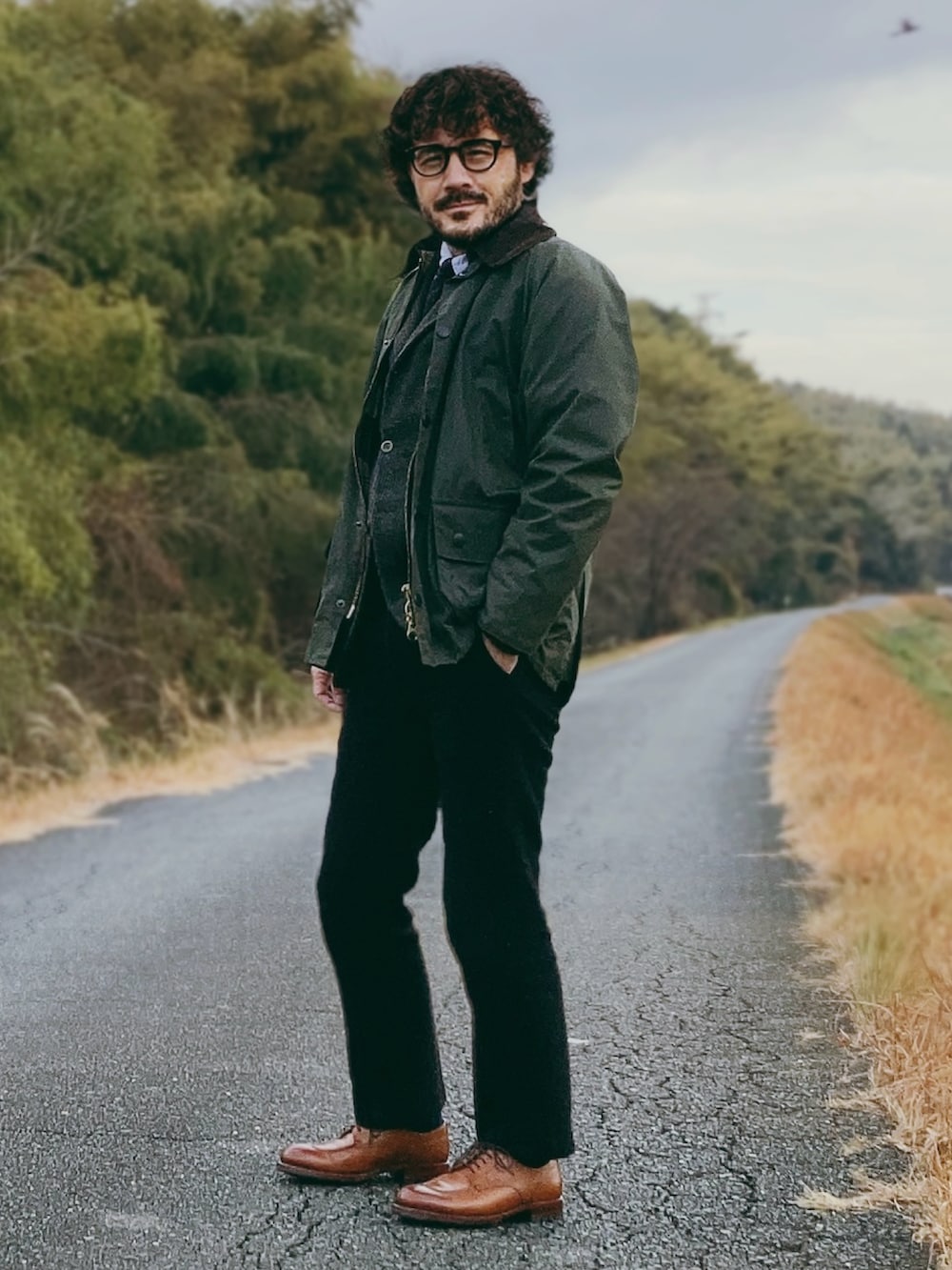 グリーン系のその他アウター、グレー系のテーラードジャケット、ブラック系のスラックスを着用したメンズの冬コーディネートの3枚目の写真