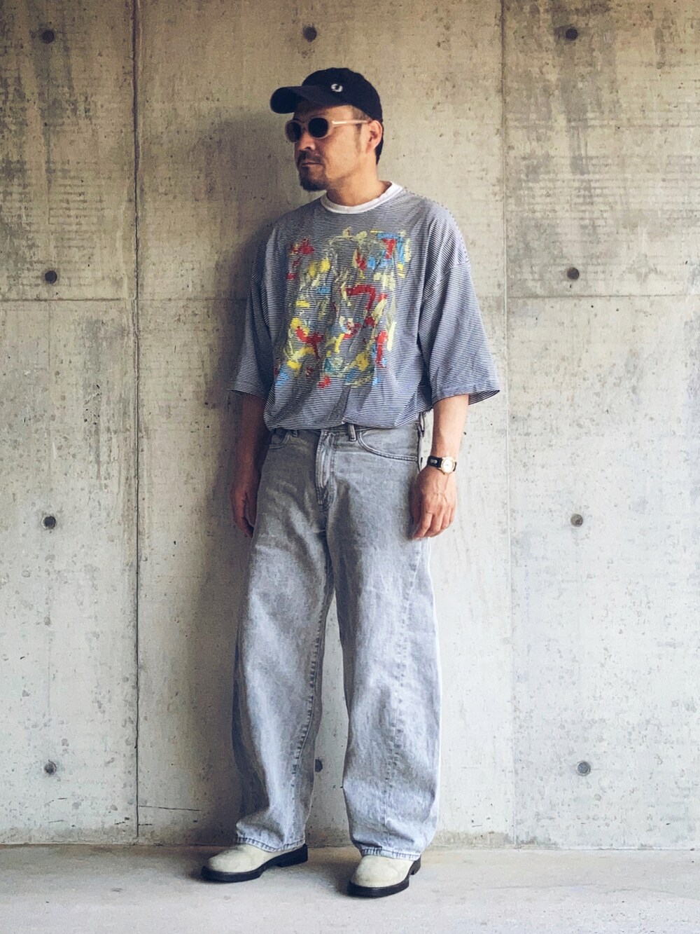 グレー系のデニムパンツ、ホワイト系のTシャツ/カットソー、ベージュ系のブーツを着用したメンズの夏コーディネートの2枚目の写真