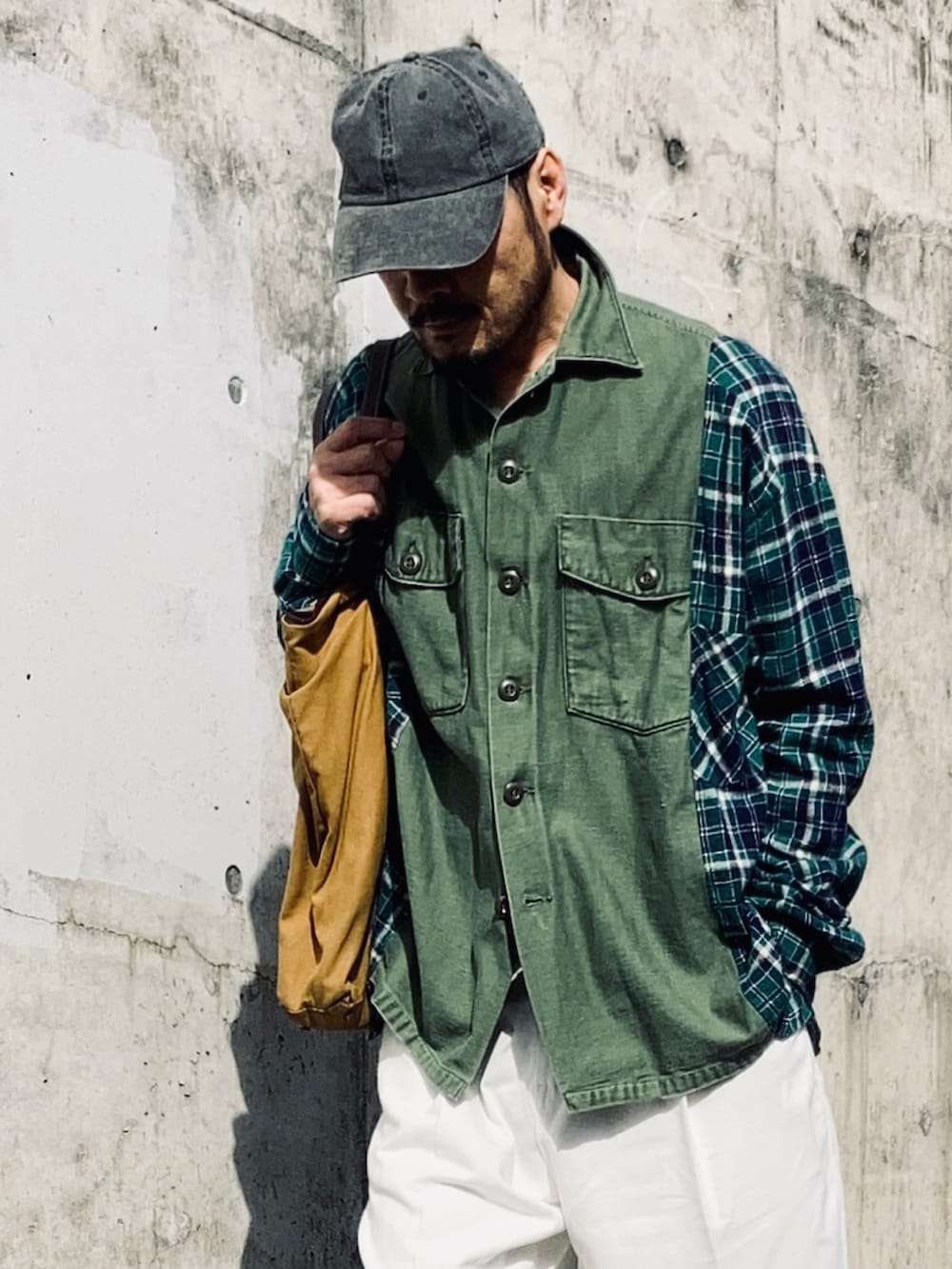 グリーン系のシャツ/ブラウス、ホワイト系のスラックス、イエロー系のブーツを着用したメンズの春コーディネートの3枚目の写真