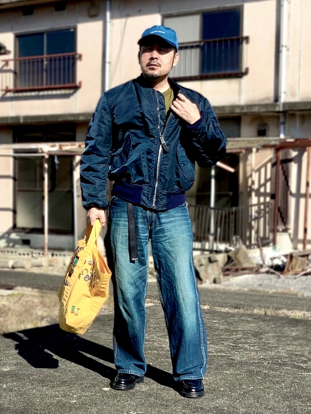 ブルー系のMA-1、ブルー系のデニムパンツ、ブラック系のローファーを着用したメンズの秋コーディネートの2枚目の写真