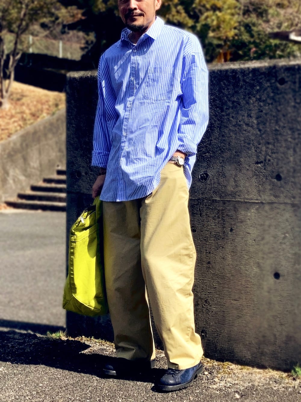 ブルー系のシャツ/ブラウス、ベージュ系のチノパンツ、ブルー系のスニーカーを着用したメンズの春コーディネートの3枚目の写真