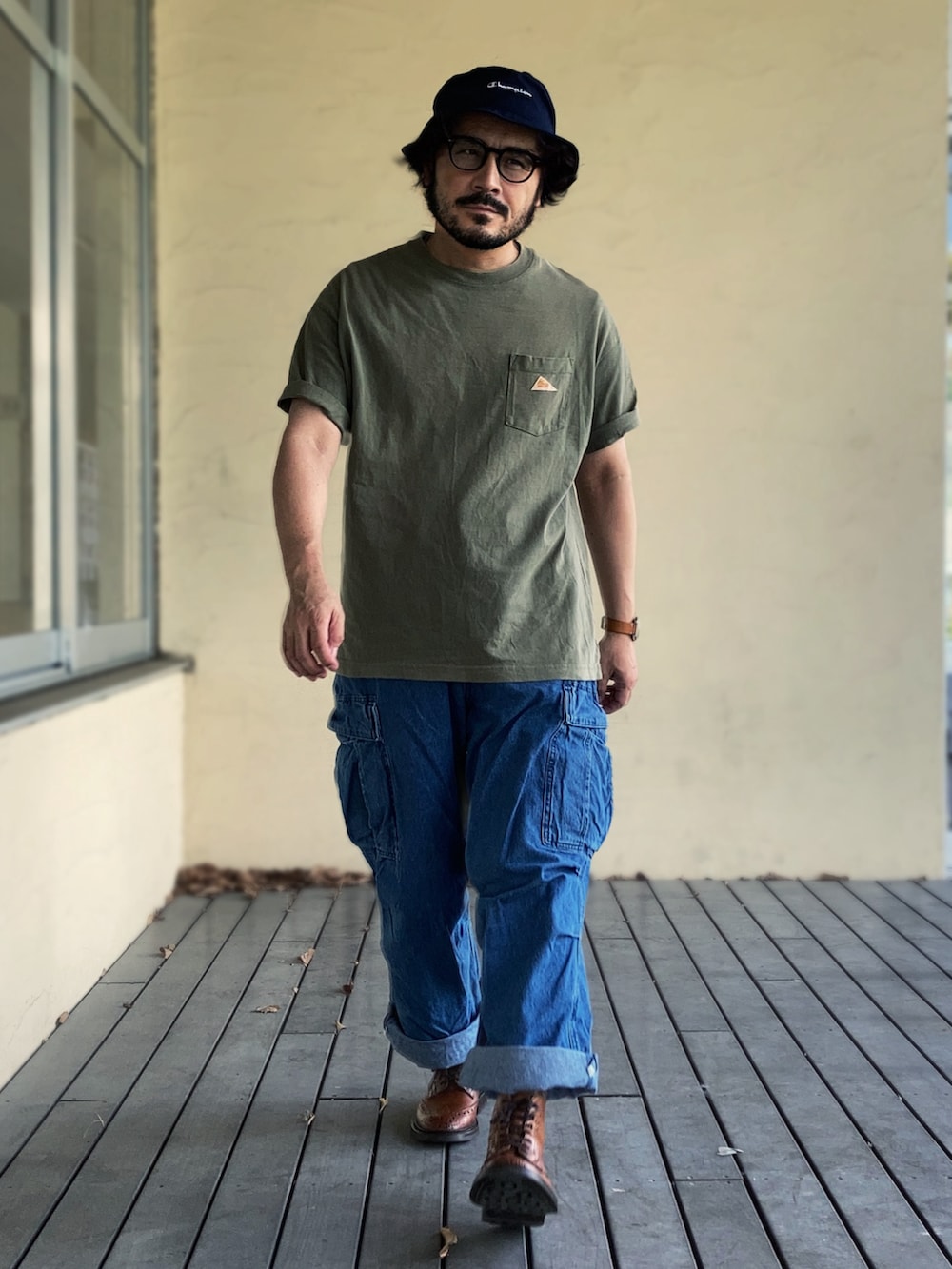 ブラウン系のブーツ、グリーン系のTシャツ/カットソー、ブルー系のカーゴパンツを着用したメンズの秋コーディネートの2枚目の写真