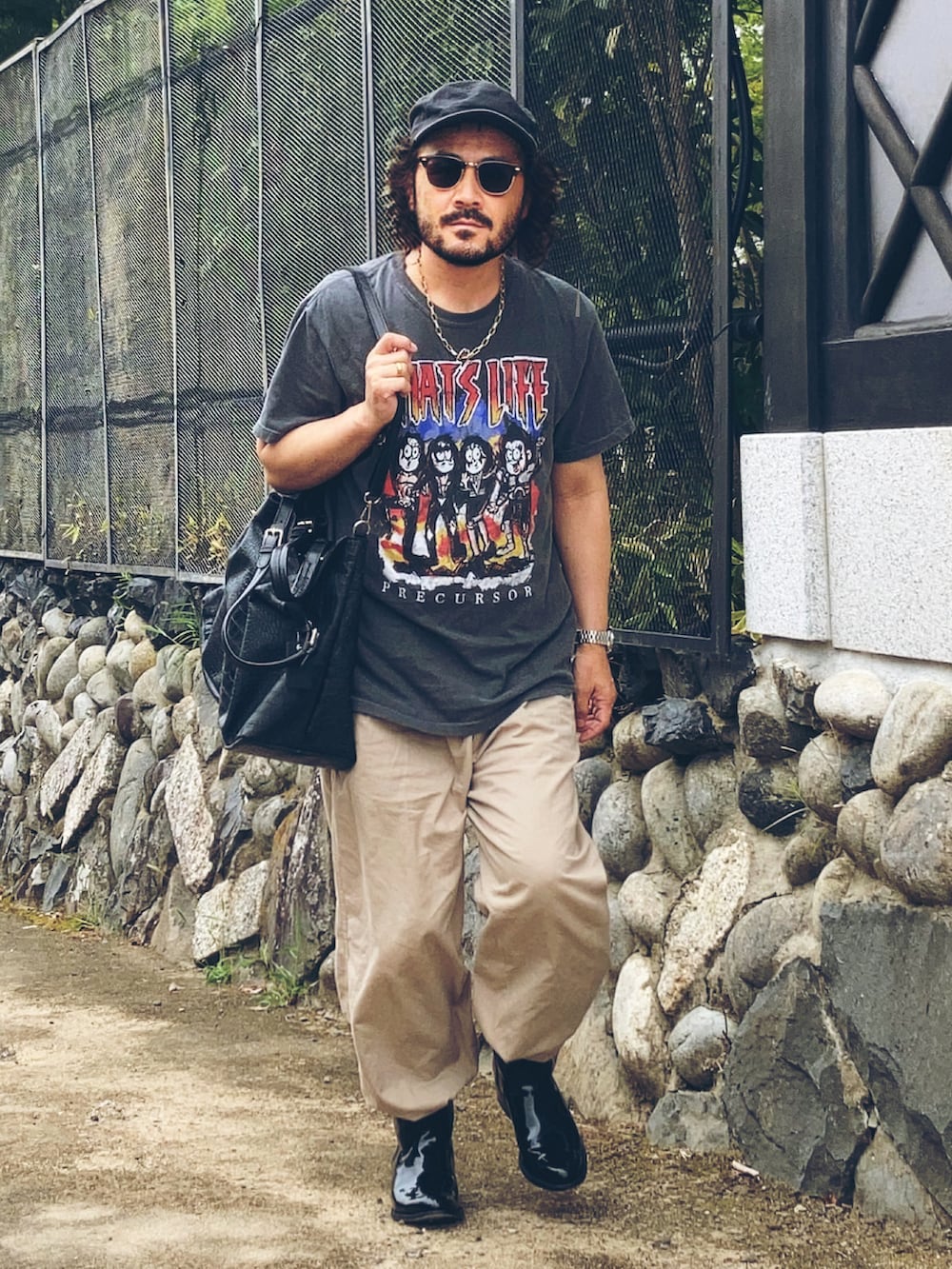 グレー系のTシャツ/カットソー、ベージュ系のスラックス、ブラック系のブーツを着用したメンズの夏コーディネートの2枚目の写真