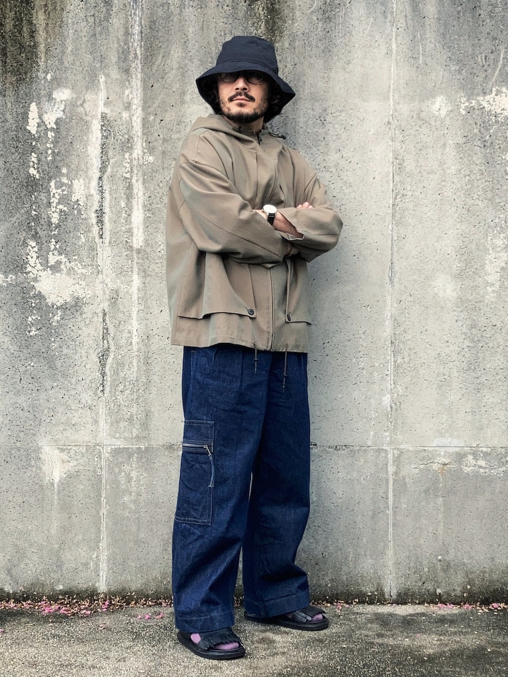 ベージュ系のブルゾン、ブルー系のデニムパンツ、ブラック系のサンダルを着用したメンズの秋コーディネートの2枚目の写真