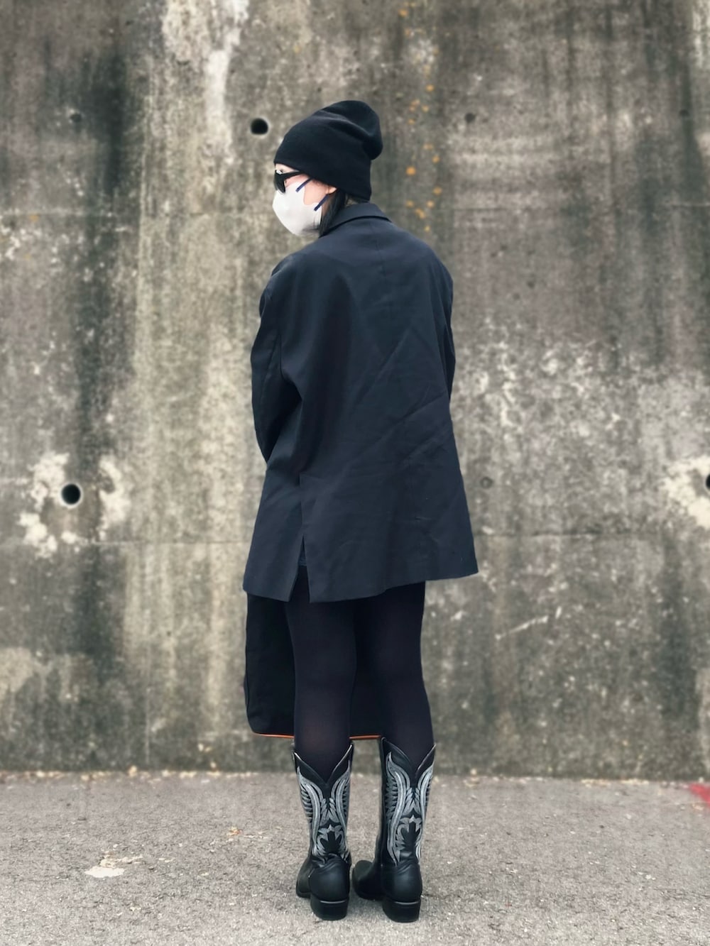 ブラック系のテーラードジャケット、ブラック系のブーツ、その他のトートバッグを着用したレディースの春コーディネートの2枚目の写真