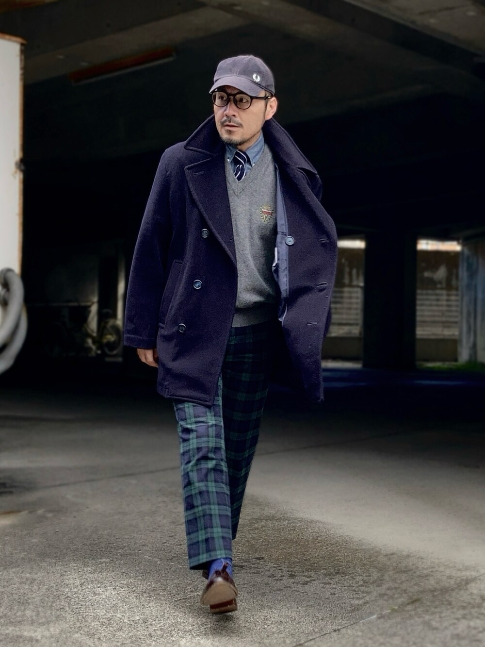 グレー系のニット/セーター、ブルー系のピーコート、グリーン系のスラックスを着用したメンズの冬コーディネートの2枚目の写真