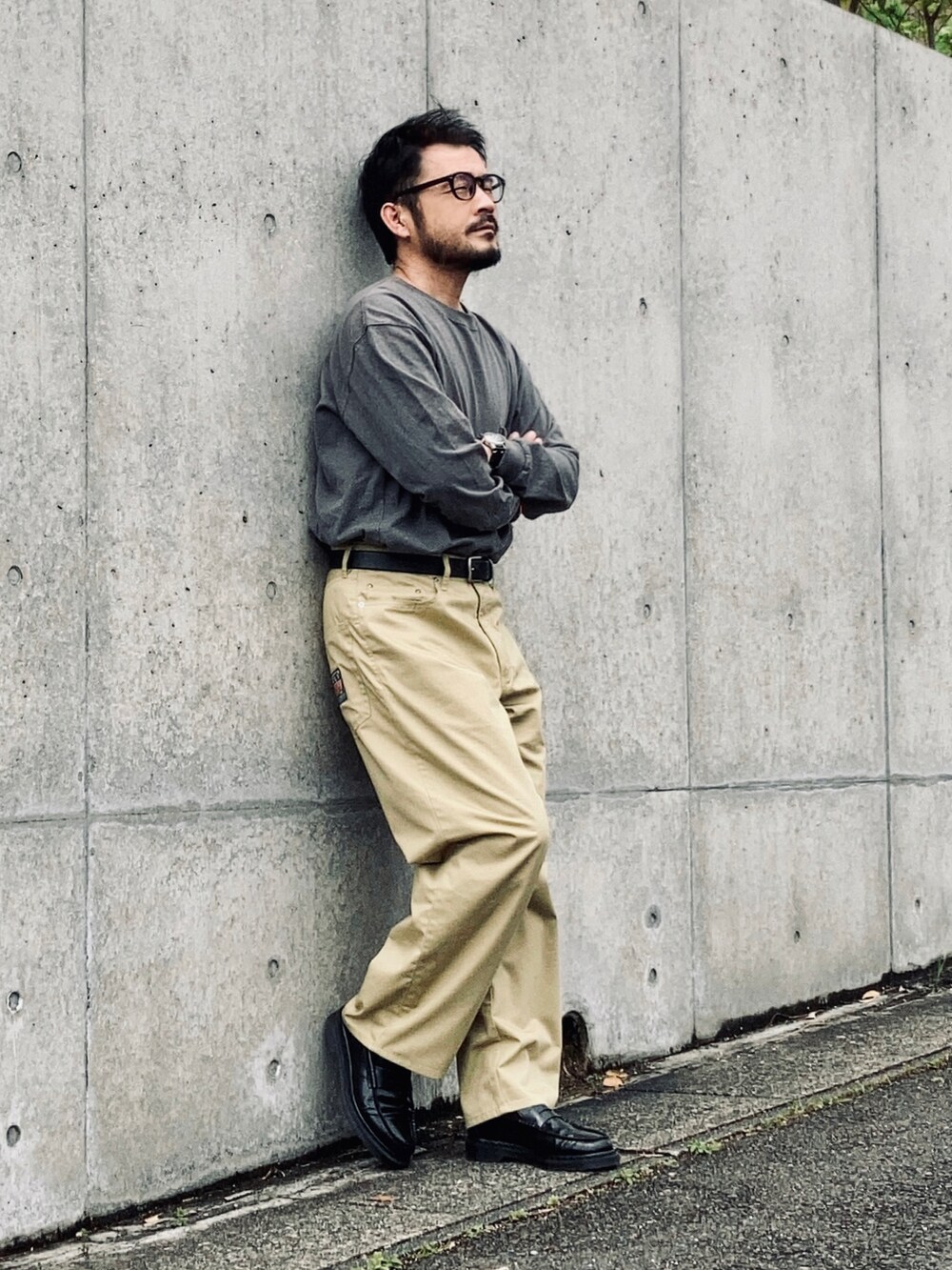 ブルー系のTシャツ/カットソー、ベージュ系のチノパンツ、ブラック系のローファーを着用したメンズの春コーディネートの2枚目の写真