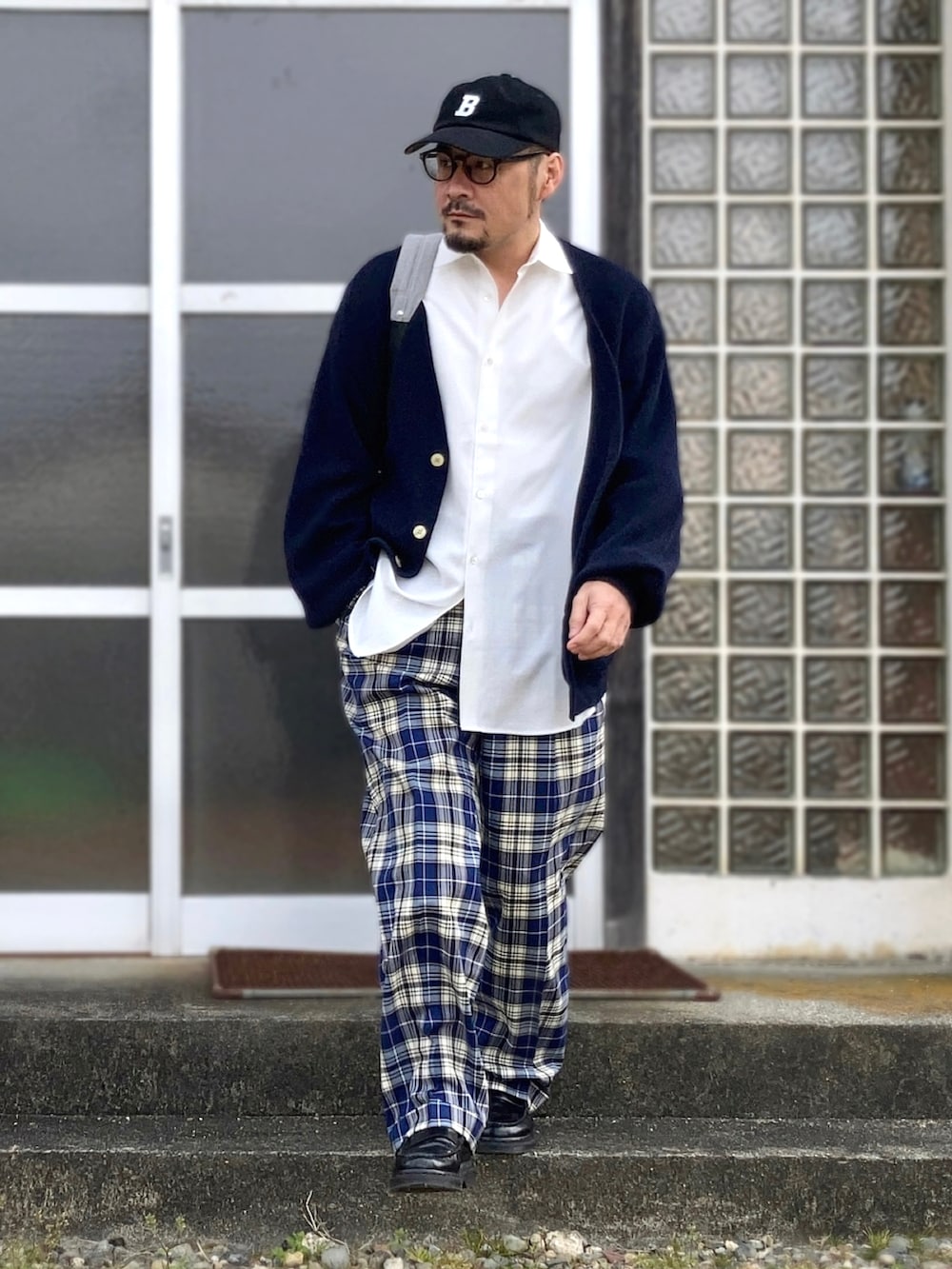 ホワイト系のシャツ/ブラウス、ブルー系のカーディガン/ボレロ、ブルー系のスラックスを着用したメンズの春コーディネートの2枚目の写真