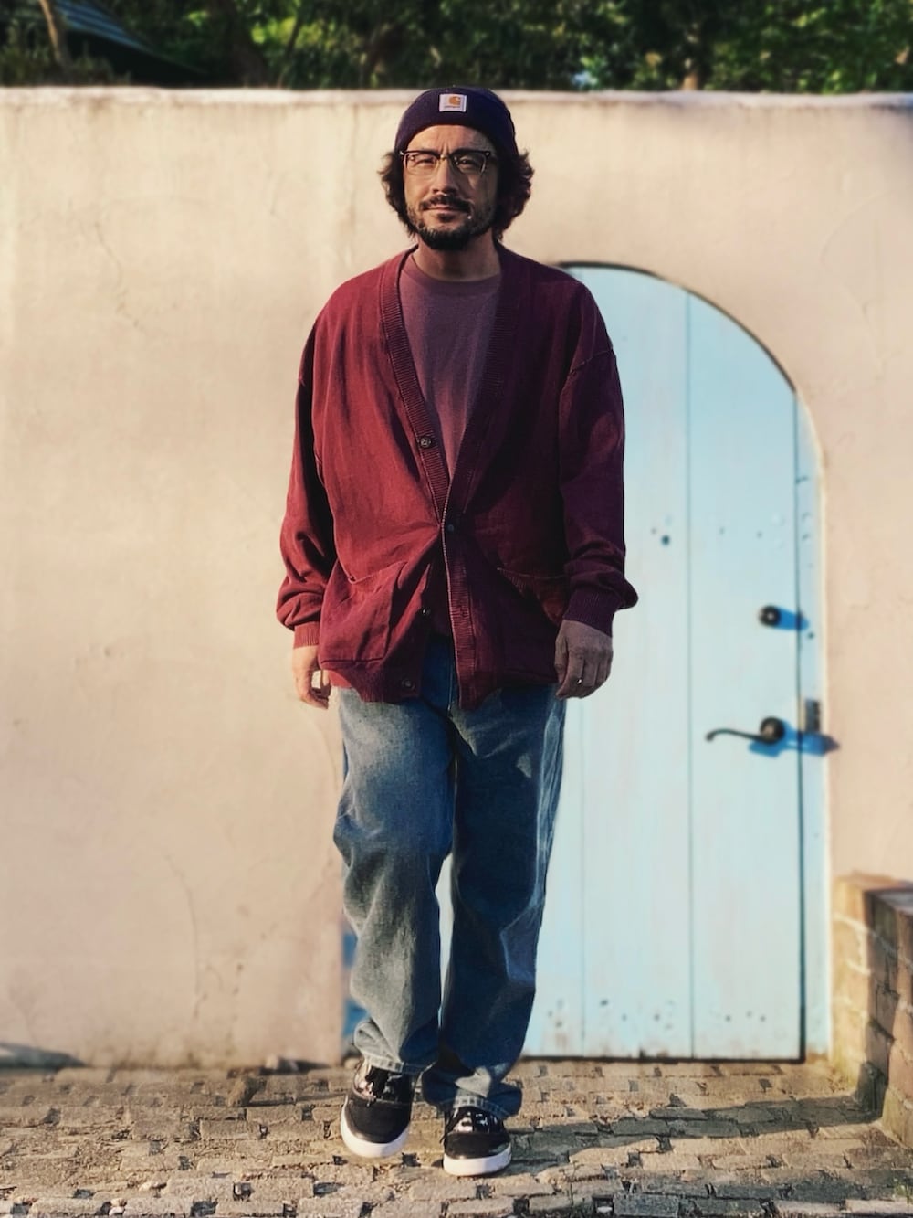 レッド系のカーディガン/ボレロ、ピンク系のTシャツ/カットソー、ブルー系のデニムパンツを着用したメンズの春コーディネートの2枚目の写真