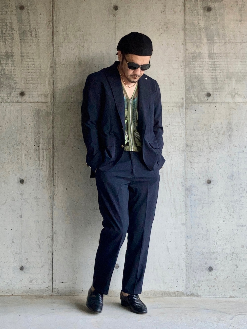 グリーン系のベスト、ブルー系のタンクトップ、ブルー系のテーラードジャケットを着用したメンズの秋コーディネートの3枚目の写真