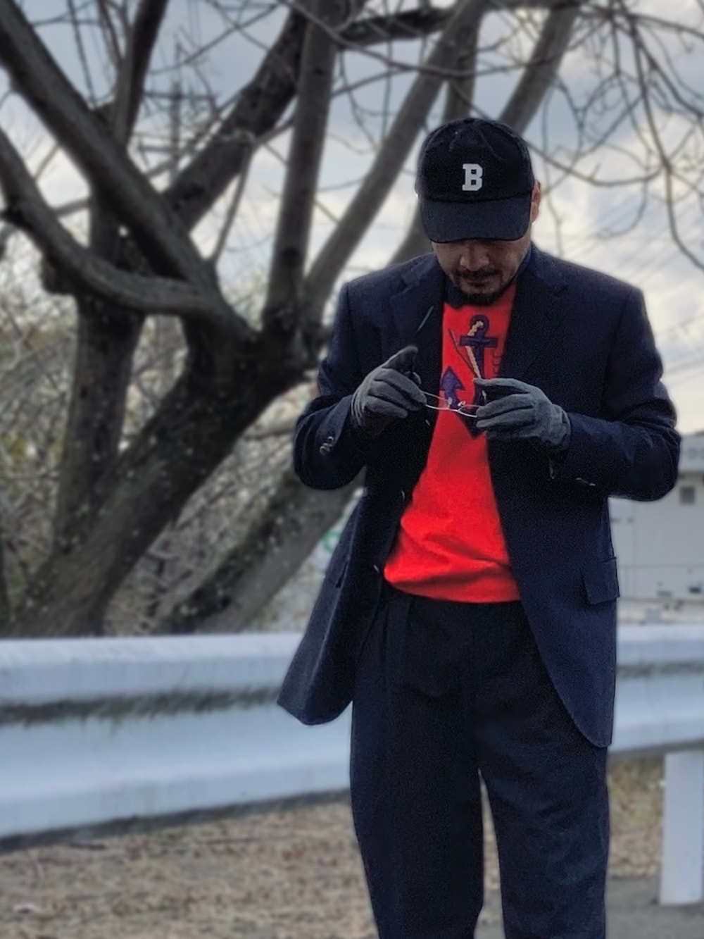 レッド系のスウェット、ブルー系のテーラードジャケット、ブラック系のスラックスを着用したメンズの春コーディネートの3枚目の写真