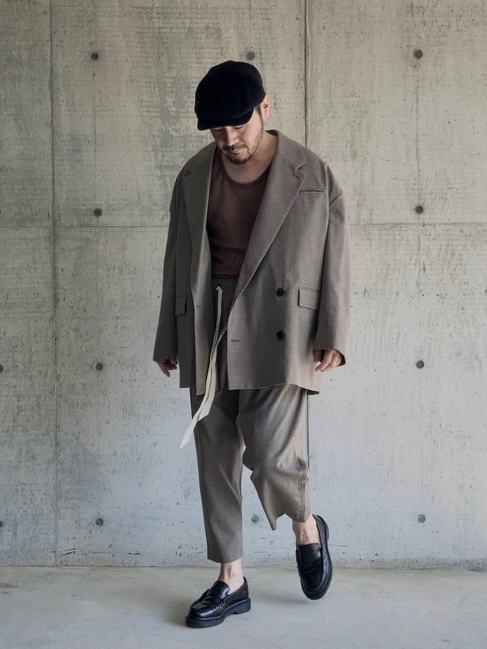ブラウン系のタンクトップ、ブラウン系のテーラードジャケット、ブラウン系のスラックスを着用したメンズの秋コーディネートの2枚目の写真