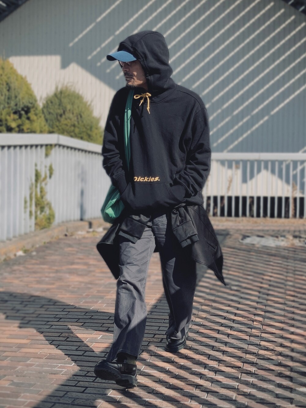 ブラック系のパーカー、ブラック系のジャケット/アウター、グレー系のスラックスを着用したメンズの冬コーディネートの4枚目の写真