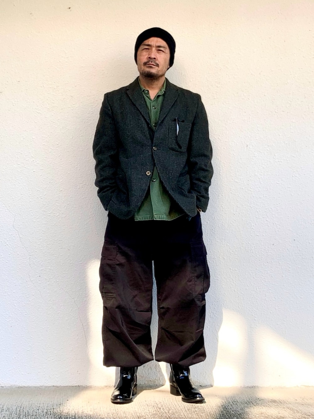 グリーン系のシャツ/ブラウス、グレー系のテーラードジャケット、ブラック系のカーゴパンツを着用したメンズの秋コーディネートの2枚目の写真