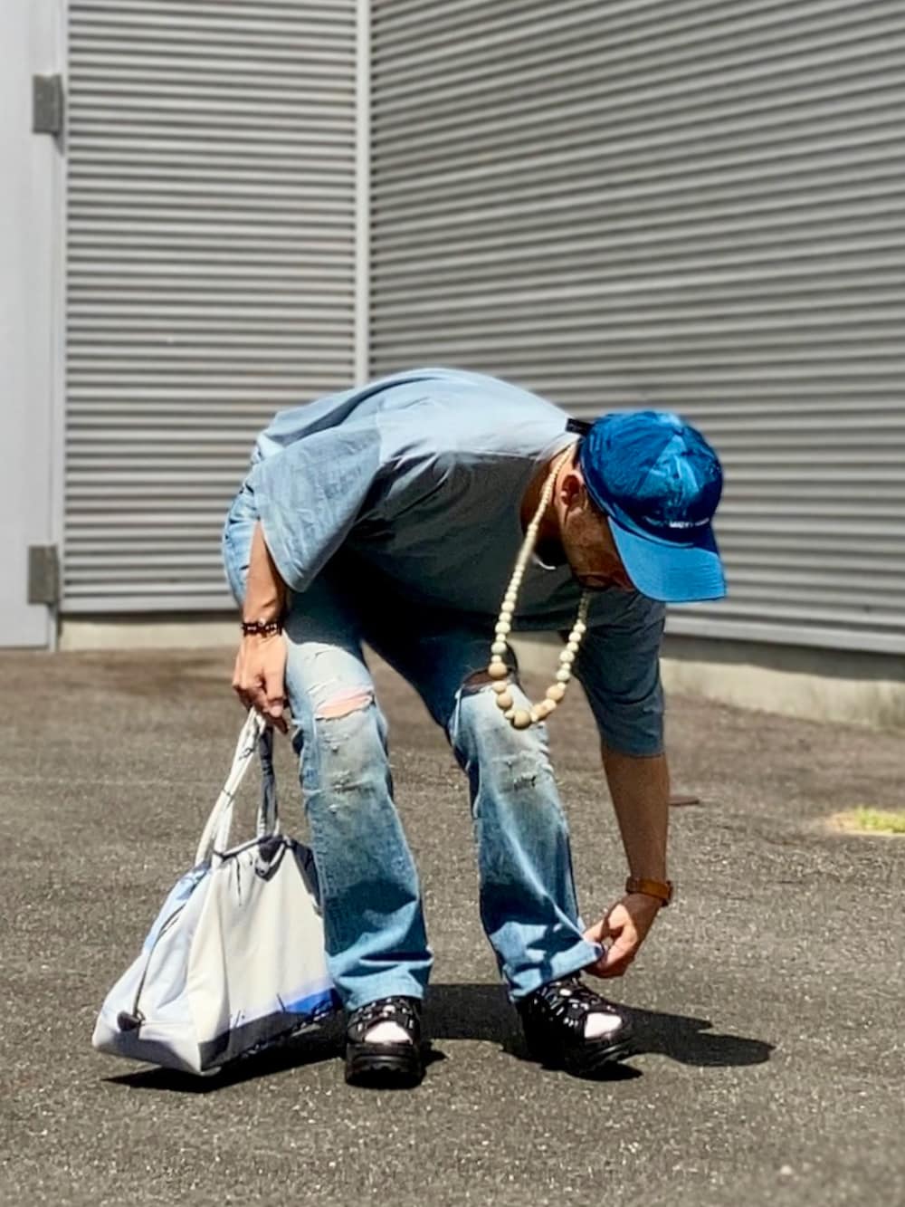グリーン系のTシャツ/カットソー、ブルー系のデニムパンツ、ブラック系のサンダルを着用したメンズの夏コーディネートの2枚目の写真