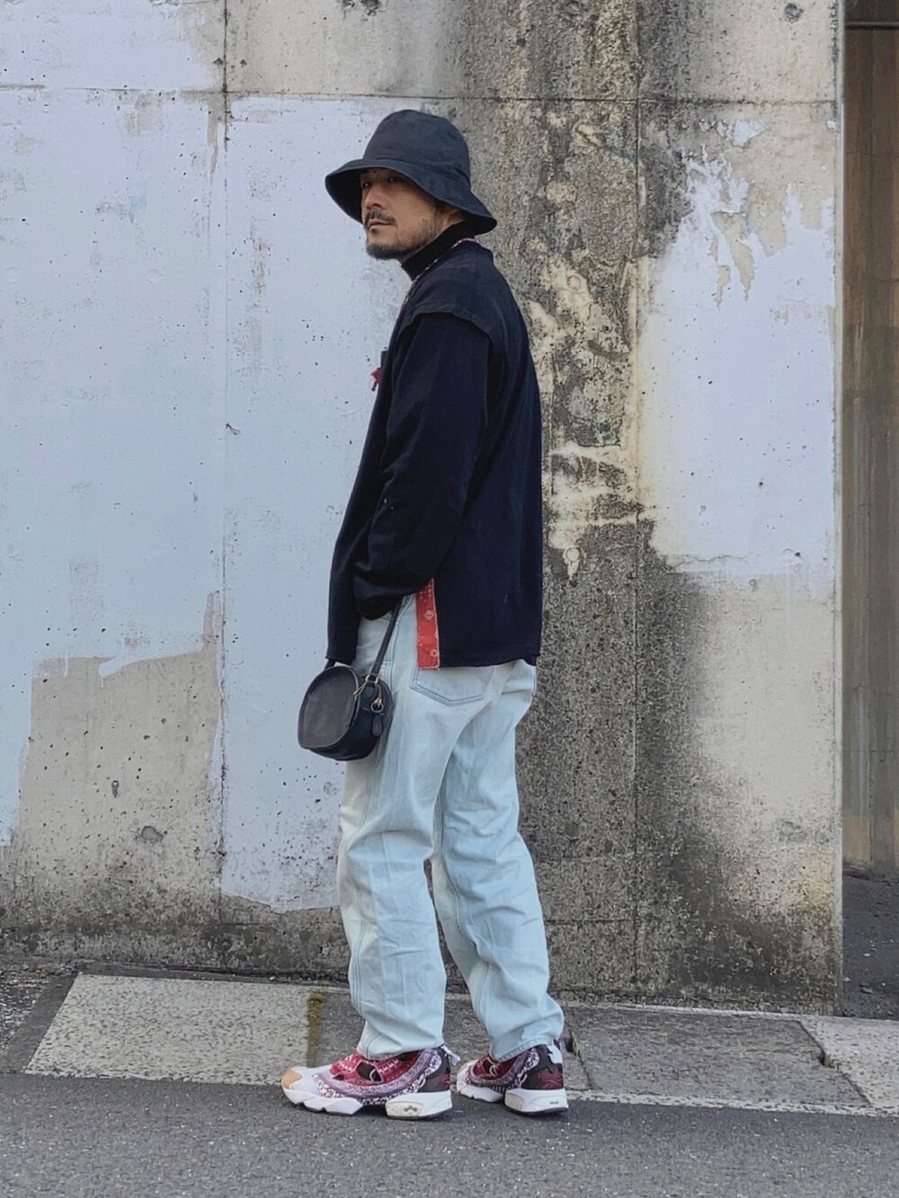 ブラック系のTシャツ/カットソー、ブルー系のデニムパンツ、レッド系のスニーカーを着用したメンズの冬コーディネートの3枚目の写真