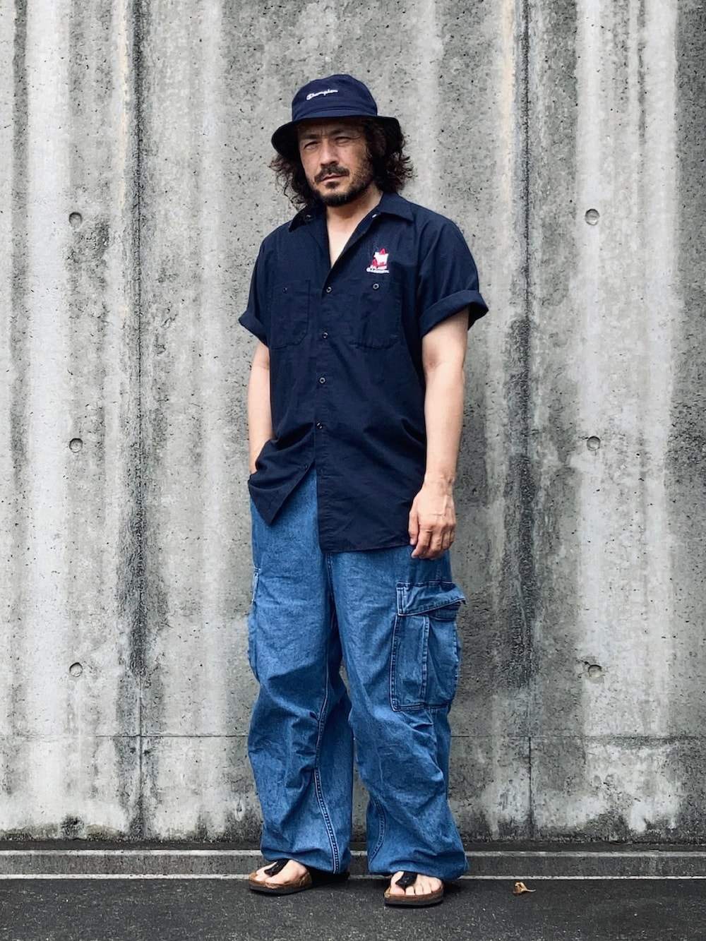 ブルー系のシャツ/ブラウス、ブルー系のカーゴパンツ、ブラック系のサンダルを着用したメンズの夏コーディネートの2枚目の写真