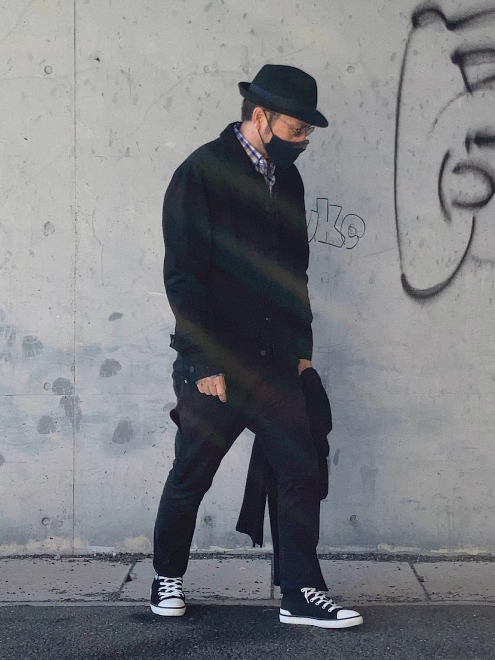 ブラック系のデニムジャケット、ブラック系のデニムパンツ、ブラック系のスニーカーを着用したメンズの冬コーディネートの3枚目の写真