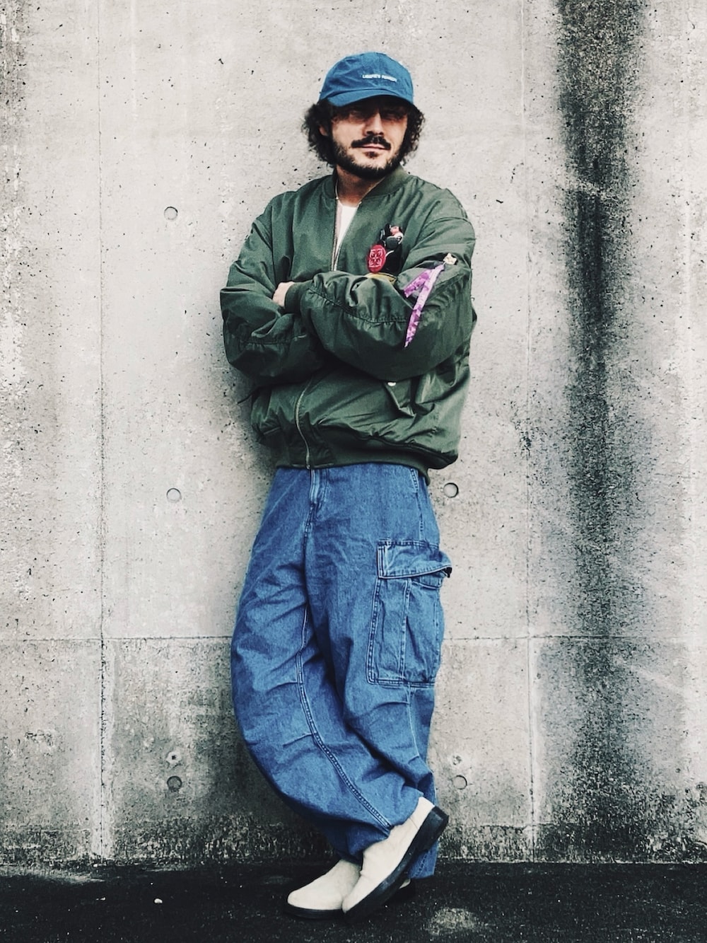 グリーン系のMA-1、ブルー系のカーゴパンツ、ベージュ系のブーツを着用したメンズの冬コーディネートの2枚目の写真