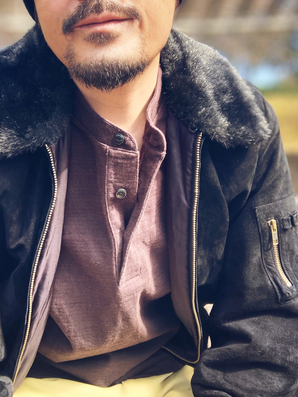 ブラック系のブルゾン、ブラウン系のTシャツ/カットソー、ベージュ系のチノパンツを着用したメンズの冬コーディネートの5枚目の写真